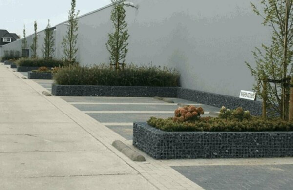 Parkeervakken gemarkeerd met schanskorf bloembakken.